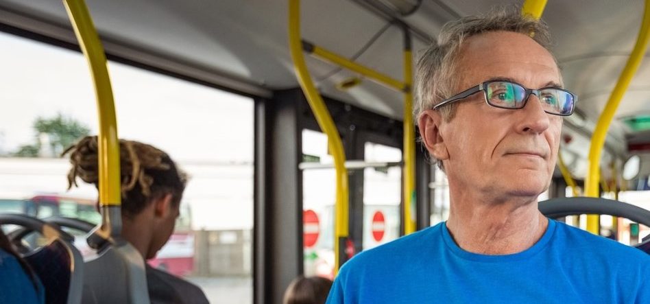 Senior mand med briller i bus