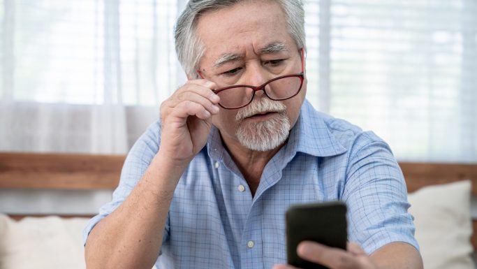 Senior mand kigger på obil og hviler brillerne på næsetippen