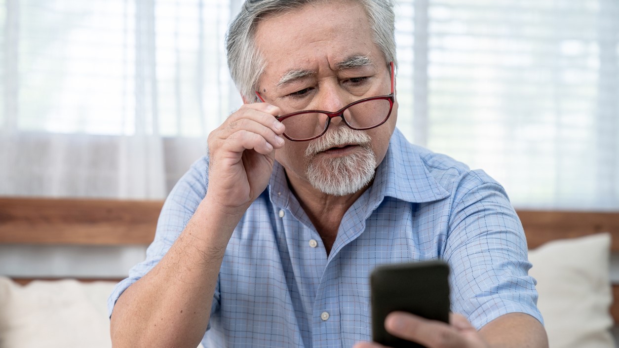 Senior mand kigger på obil og hviler brillerne på næsetippen