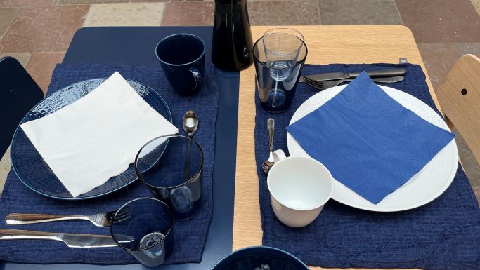 Bordopdækning med kontraster - til højre ses blå serviet på hvid tallerken på blå dækkeserviet