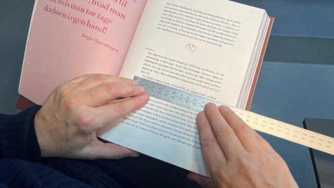En lineal holdes under en sætning i en bog for at gøre læsningen nemmere.