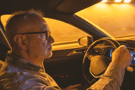 Senior mand kører bil i mørke
